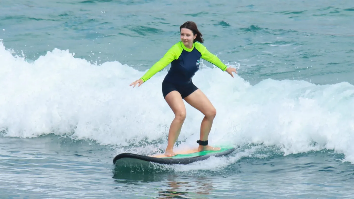 NASA Surf School guest riding a blue surfboard